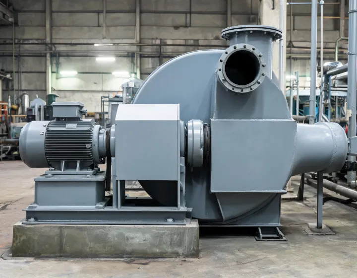Industrial centrifugal blower on a steel base with inlet duct and motor drive in a process plant